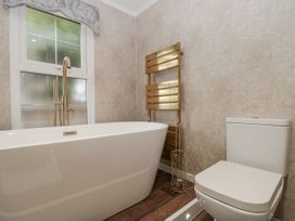 A bathroom with a bathtub and toilet at The Cabin in Thornton Dale