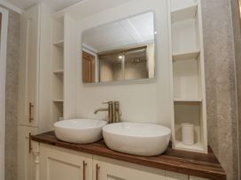 A bathroom with double sinks and a mirror at The Cabin in Thornton Dale
