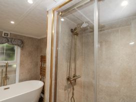 A bathroom with a bathtub and shower at The Cabin in Thornton Dale