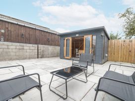 An outdoor patio with chairs and a shed at The Cabin Thornton Dale