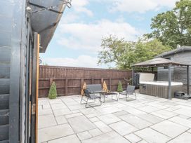 An outdoor area with a patio and hot tub at The Cabin in Thornton Dale