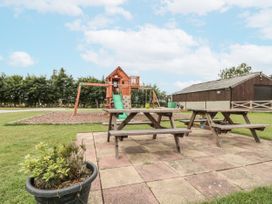 An outdoor area with a play structure and picnic tables at The Cabin in Thornton Dale