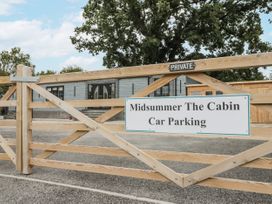 A parking area with a wooden gate at Midsummer The Cabin in Thornton Dale