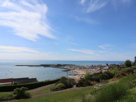 A view of a beach and sea area with boats and people at The Roost in Whitford Nr. Colyton