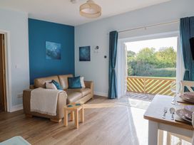 A living room with a sofa and dining area at The Roost in Whitford Nr. Colyton