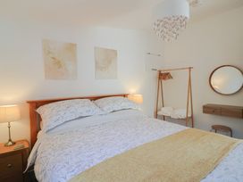 A bedroom with a bed and bedside lamp at The Roost in Whitford Nr. Colyton