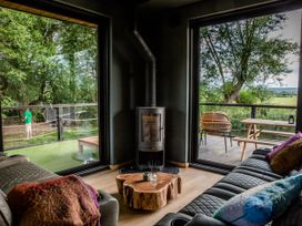 A living room with large windows and a stove at The Red House in Farndon