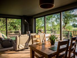 A living room with a sofa and dining table at The Red House in Farndon