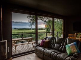 A living room with a sofa and sliding glass doors at The Red House in Farndon