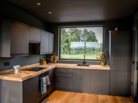 A kitchen with modern cabinets and a large window at The Red House in Farndon