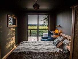 A bedroom with a bed and armchair at The Red House in Farndon