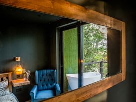 A bedroom with a bathtub visible on the balcony at The Red House in Farndon