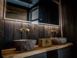 A bathroom with two stone sinks and a mirror at The Red House in Farndon