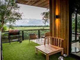 An outdoor seating area with a grill and a bench at The Red House in Farndon