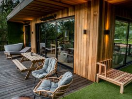 A patio area with seating and a bathtub at The Red House in Farndon