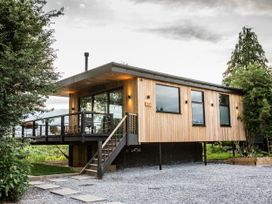 A house with wooden exterior and deck at The Red House in Farndon