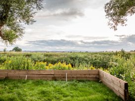 A garden with a wooden fence and a view of greenery at The Red House in Farndon