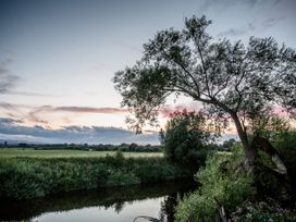A river surrounded by grass and trees at The Red House in Farndon