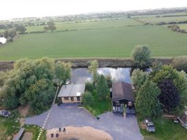An outdoor area with a house and garden near a river at The Larch House in Farndon