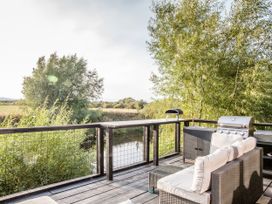A deck with outdoor seating and grill at The Larch House in Farndon