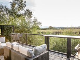 An outdoor patio with seating and bar stools at The Larch House Farndon