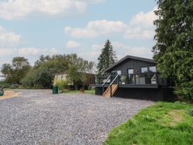 A house with a deck and steps in a garden at The Larch House in Farndon