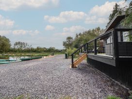 An outdoor area with stairs leading to a deck by a lake at The Larch House in Farndon