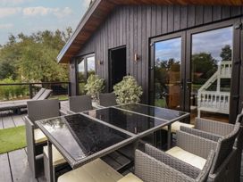 An outdoor seating area with a table and chairs at The Larch House in Farndon
