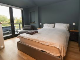 A bedroom with a bed and two nightstands at The Larch House in Farndon