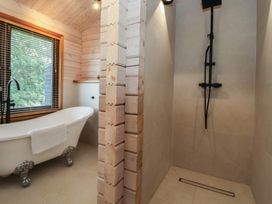 A bathroom with a bathtub and a shower at The Larch House in Farndon