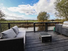 An outdoor space with a sofa and barbecue grill at The Larch House in Farndon