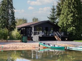 A house with a deck and kayaks at The Larch House in Farndon