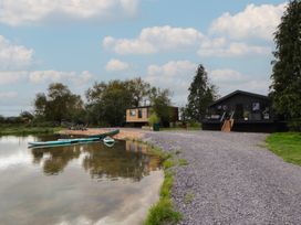 Outdoor area with buildings and canoes at The Larch House in Farndon