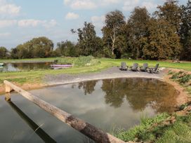 An outdoor area with water and chairs at The Larch House in Farndon