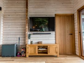 A living room with a television and media cabinet at The Larch House in Farndon