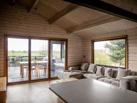 A living room with a sofa and dining area at The Larch House in Farndon