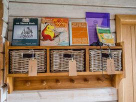 Shelves with books and storage baskets at The Larch House in Farndon
