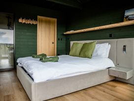 A bedroom with a bed and green pillows at The Larch House in Farndon