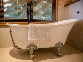 A bathtub with a towel draped over it at The Larch House in Farndon