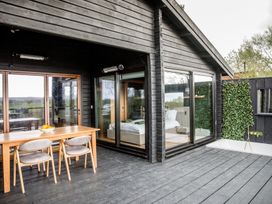 An outdoor patio with a dining table and chairs at The Larch House in Farndon