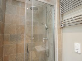 A shower with glass door and tiled walls at Granary Cottage in 