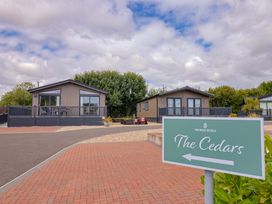 Two cabins at Pinewood Retreat with a sign pointing to The Cedars