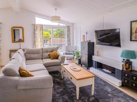 A living room with a sofa, coffee table, and television at Cedar 1 in Pinewood Retreat