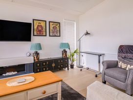 A living room with a television and artwork at Cedar 1 Pinewood Retreat