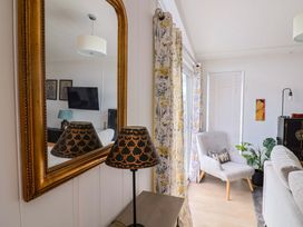 A living room with a lamp and a mirror at Cedar 1 Pinewood Retreat