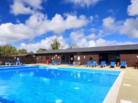 An outdoor pool area with lounge chairs at Cedar 1 Pinewood Retreat