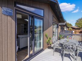 An outdoor patio with a table and chairs at The Cedars 1 Pinewood Retreat in Rousdon near Lyme Regis