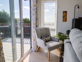 A living room with a chair and sliding door at Cedar 1 Pinewood Retreat in Rousdon near Lyme Regis