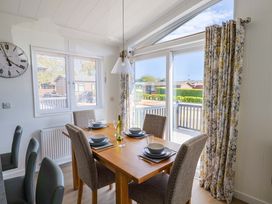 A dining area with a table and chairs at Cedar 1 in Pinewood Retreat in Rousdon near Lyme Regis