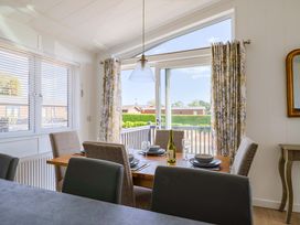 A dining room with a table set for dinner at Cedar 1 in Pinewood Retreat in Rousdon near Lyme Regis
